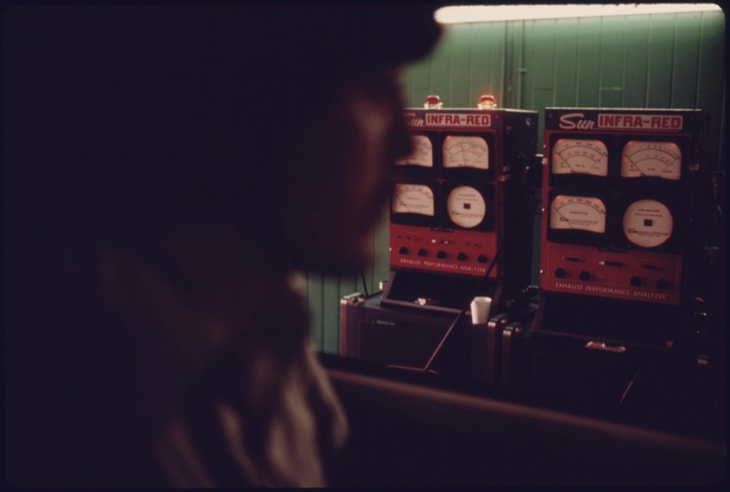 Dark 1975 photograph of a person watching a van dashboard at night.