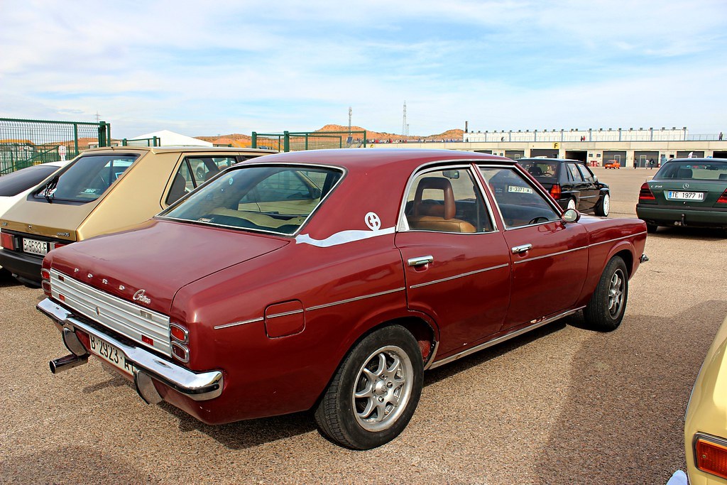 Red Ford Cortina parked in a lot.